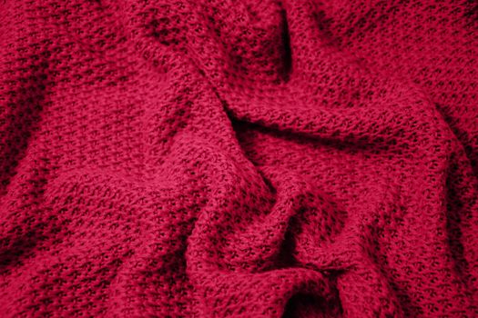 Viva Magenta toned colour monochrome texture knitted fabric. Dark pink knitted Jersey as textile background. Monochrome color background. Trendy color 2023.