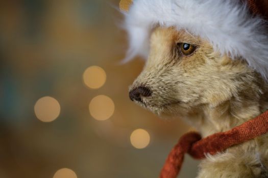 Christmas card greeting with cute handmade teddy bear with red Santa cap on brown background. high quality photo