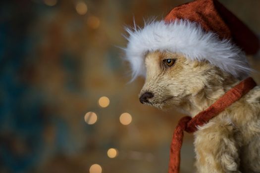 Christmas card greeting with cute handmade teddy bear with red Santa cap on brown background. high quality photo