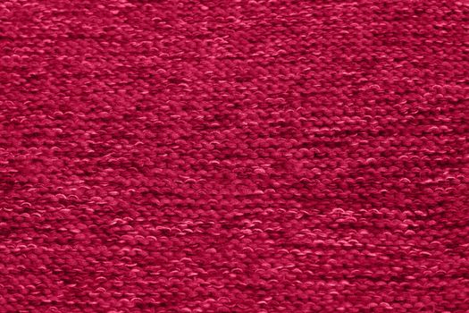 Viva Magenta toned colour monochrome texture knitted fabric. Dark pink knitted Jersey as textile background. Monochrome color background. Trendy color 2023.