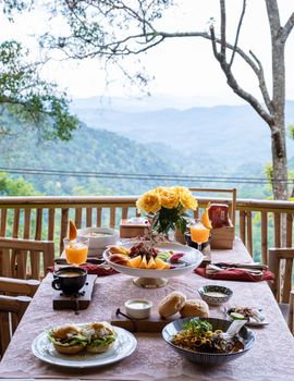 top view of a luxury breakfast in the mountains of Chiang Mai Thailand, luxury breakfast with Chiang Mai curry noodle soup or Khao Soi Gai and fruits and coffee on the table. 