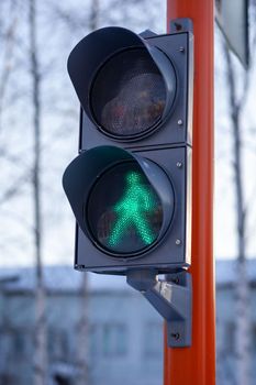 Green light on a pedestrian traffic light. Safe crossing of the road by pedestrians. 
