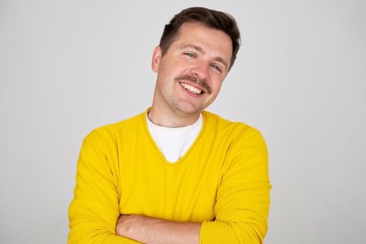 Young handsome man with moustache. happy face smiling with crossed arms looking at the camera. Positive person. 