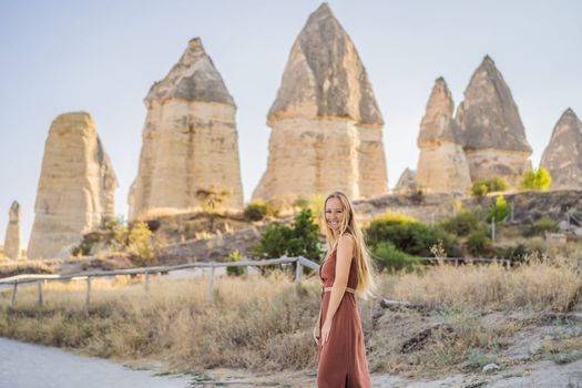 Woman tourist on background of Unique geological formations in Love Valley in Cappadocia, popular travel destination in Turkey.