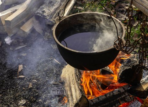 Pot On The Fire. Cauldron with liquid on fire from wood.