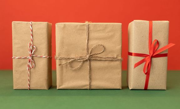 three craft wrapped gifts over red background. High quality photo