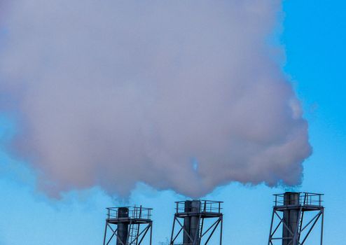 Chimney white smoke three in a row on a blue sky