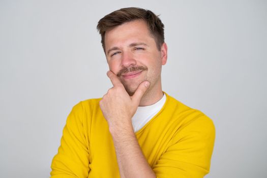 Thoughtful caucasian young man touch chin with finger thinking or considering, pensive European man making decision or imagining