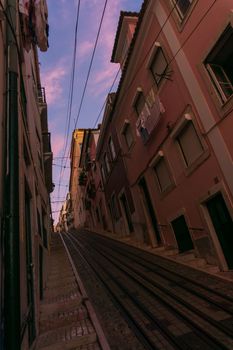 Narrow street with rails in Lisbon at sunset