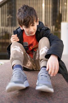 Portrait caucasian young boy worried and pain face hands joint hold leg pain because of twisted ankle broken at the outdoor street, healthy exercise Injury from playing.