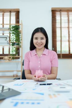 investment plan, young asian woman keep coin money in jar and using calculator to calculate savings.