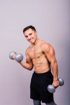 Shirtless bodybuilder showing his great body and holding dumbells.