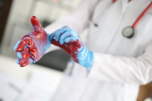 Closeup of hands of surgeon in blood after operation. Medical error and patient death concept