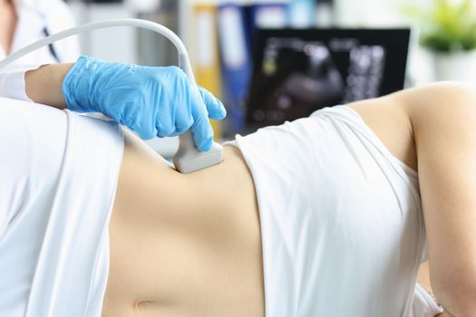 Woman undergoes ultrasound scan of kidneys and internal organs in clinic. Chronic kidney disease and hydronephrosis concept