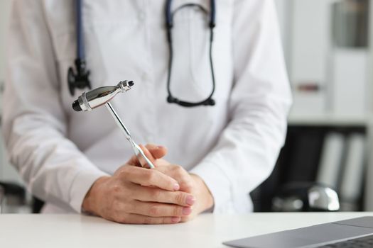 Doctor neurologist with hammer in hands in clinic. Neuropathologist is doctor who treats diseases and lesions of human nervous system
