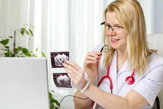 Female doctor showing her patient picture of ultrasound image of her baby on the laptop. teletreatment. gynecology gynecologist education medicine healthcare feminine health pregnancy preparation prevention.