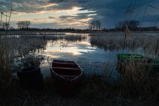 Smal boats on the shore of the lake on a cloudy evening