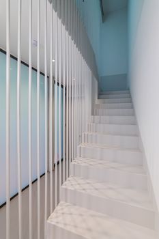 Beautiful white staircase to the second floor with soft blue lighting. Original design solution of the floor-to-ceiling fence made of metal white rods gives the effect of weightlessness