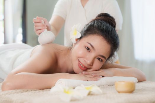 Young woman doing relaxing massage in spa salon. Female being massaged by a masseur. Spa and medicine concept.