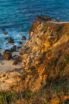 The rocky shore of the Atlantic Ocean in the rays of the setting sun landscape