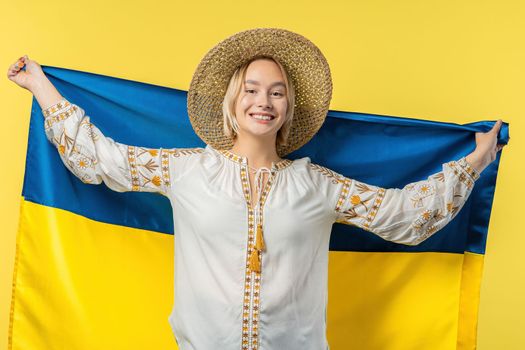 Happy woman with national Ukrainian flag on yellow. Ukraine, patriot, victory in war celebration, banner, Independence day. High quality photo