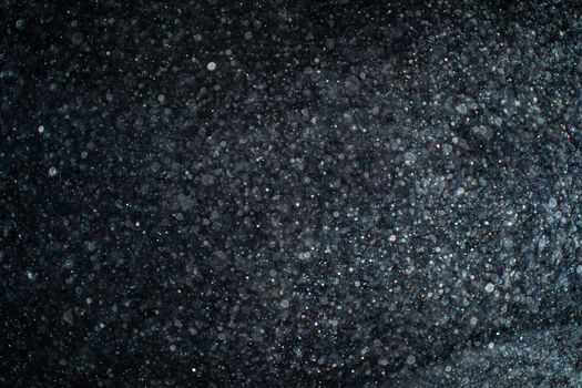 Abstract real dust particles on black background. Glittering sparkling bokeh overlay design with copy space for text. High quality photo