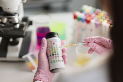 Test made with vial with a strip of reagent for urine analysis. Ketosis control and laboratory research concept
