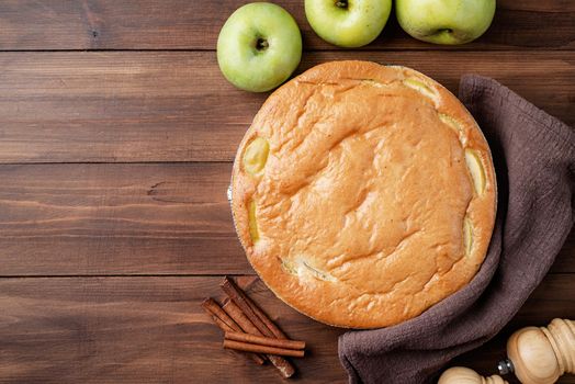 Traditional charlotte apple pie charlotte on wooden table with fresh apple and cinnamon , view from above