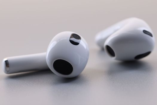 Bluetooth wireless headphones or earbuds or earphones on gray background. Fashion stylish headphones concept