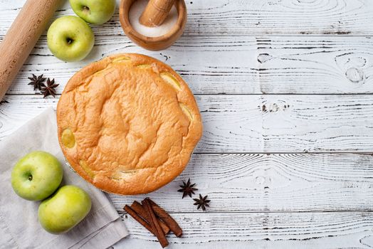 Traditional charlotte apple pie charlotte on white wooden table with fresh apple and cinnamon , view from above