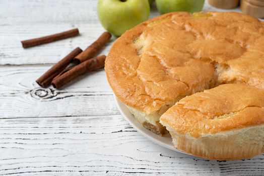 Traditional charlotte apple pie charlotte on concrete table with fresh apple and cinnamon , view from above