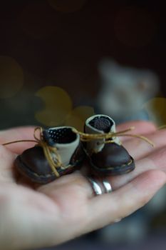 leather small shoes for teddy bear or doll on the hand. the concept of light industry for the manufacture of stylish fashionable shoes for children with small feet and their parents. High quality photo