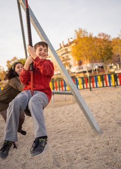 Mum and son enjoying together in a playground. Family love concept.