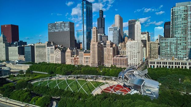 Image of Pavilion in Millennium Park of Chicago next to line of large skyscrapers