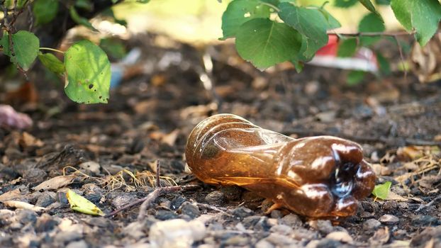 close-up, on the ground lying old used plastic bottle. garbage, trash, rubbish on street, outdoors. ecology, pollution of the environment. High quality photo