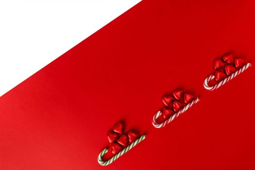 Christmas background with a sled, candy and a caramel cane. red and white Christmas background with space to copy. Merry Christmas and Happy New Year. creative Christmas composition