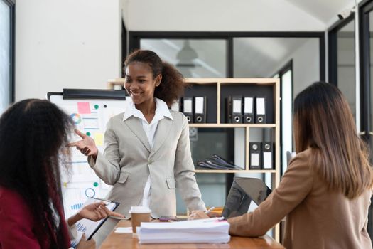 Asian business workgroup designers team with asian woman leader discuss paperwork financial report statistical data, forecasting working on common project. Brainstorm, briefing activity concept..