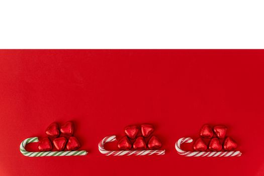 Christmas background with a sled, candy and a caramel cane. red and white Christmas background with space to copy. Merry Christmas and Happy New Year. creative Christmas composition