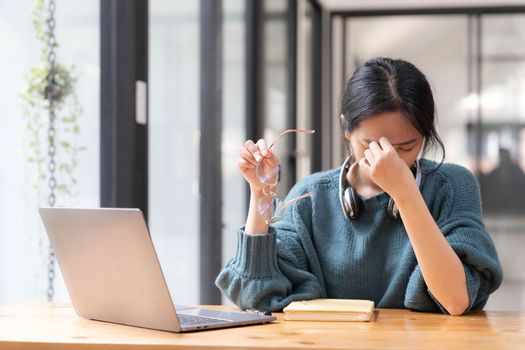 Shot of stressed woman working from home on laptop looking worried, tired and overwhelmed...