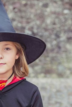 young fair-haired sorceress in mantle and hat.