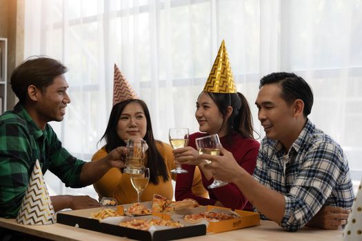 Group of asian friends eating pizza during party at home. Happy asian people having fun together, eating pizza food and beer together with happiness and fun