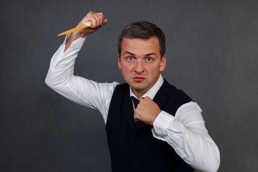 Studio portrait of an angry man wielding a large kitchen knife.