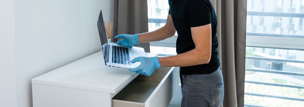 Thief with black balaclava stealing laptop. The burglar commits a crime in Luxury apartment.