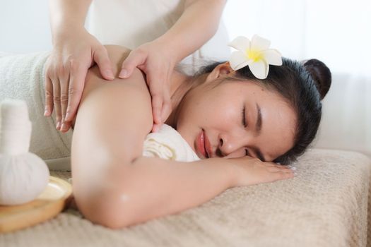 Young woman doing relaxing massage in spa salon. Female being massaged by a masseur. Spa and medicine concept.