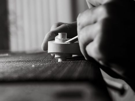 violinmaker working on a handmade contemporary stringed instrument scroll