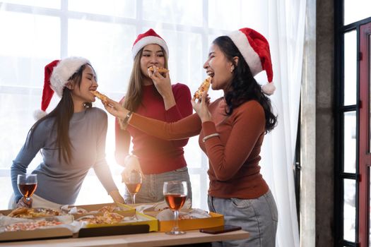 Group of young asian office girl friends having fun, talking and eating pizza together with happiness and fun. Lifestyle Concept.