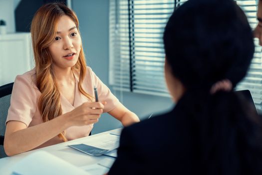 A young female asian candidate tries to impress her interviewer by being competent. International company, multicultural environment in workplace.