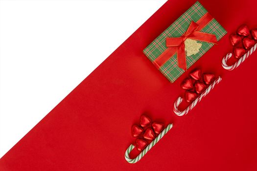 Christmas background with a sled, candy and a caramel candy. gift box. red and white Christmas background with space to copy. Merry Christmas and Happy New Year. creative Christmas composition