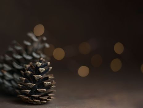 Pine cone isolated on light background. Holiday glowing backdrop. Defocused background with blinking light. Blurred Bokeh. copy space. High quality photo