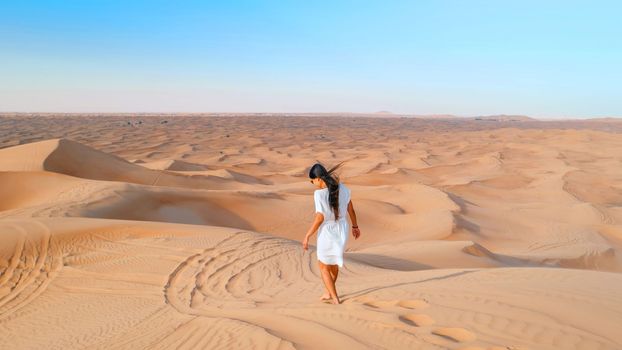 Dubai dessert sand dunes, Asian women on Dubai desert safari,United Arab Emirates, woman vacation in Dubai visit the sand dunes